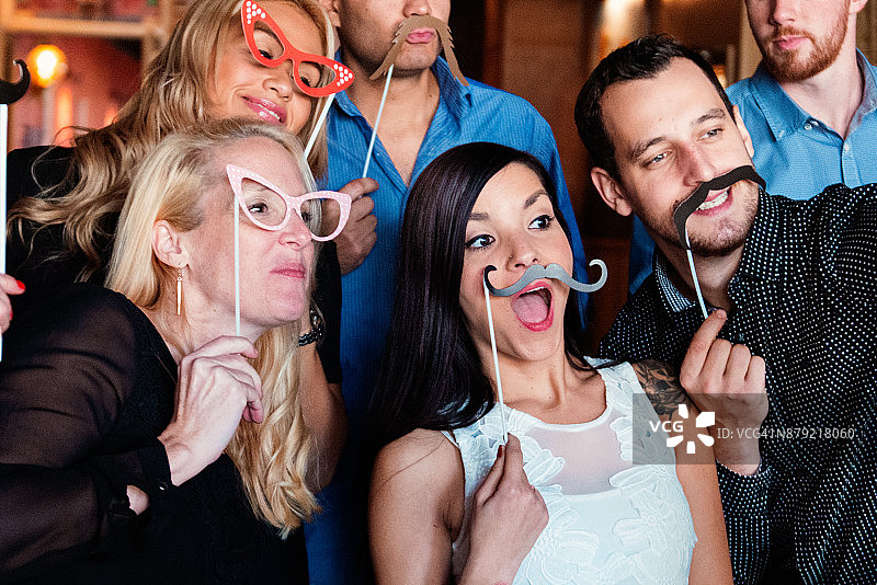 同事和职员在酒吧里用照片亭庆祝新年除夕图片素材