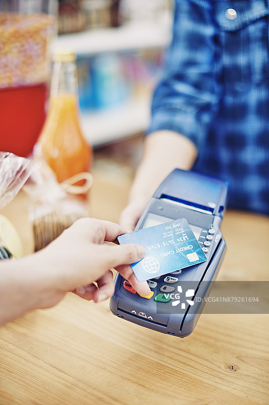 熟食店店主收到顾客的信用卡付款图片素材