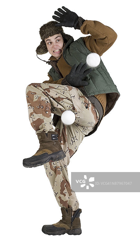 穿着迷彩服躲避雪球的男人图片素材