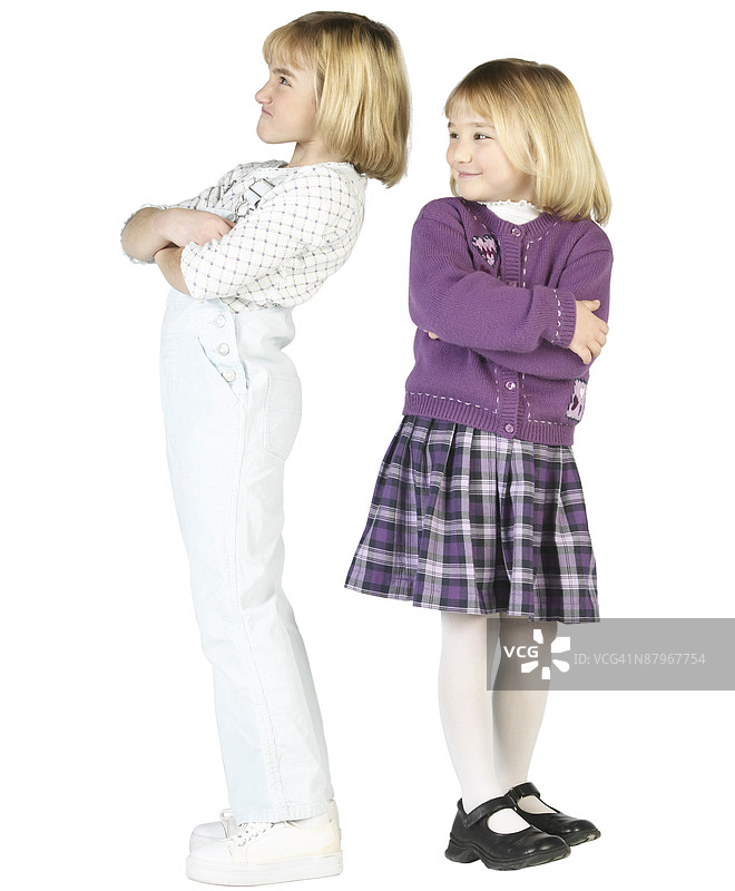 金发白人女孩站着微笑，面对一位皱眉的女孩朋友图片素材