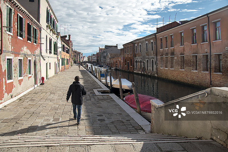 男人沿着意大利威尼斯街道行走图片素材