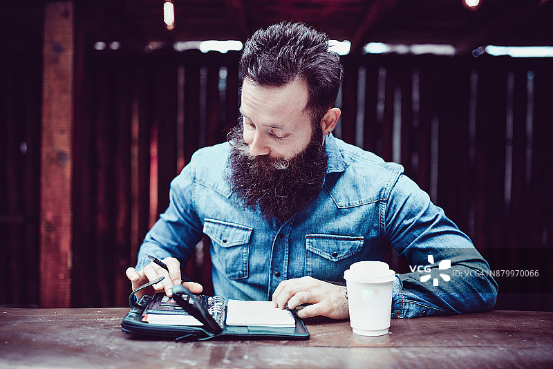 自由职业者喝着咖啡查看待办事项清单图片素材