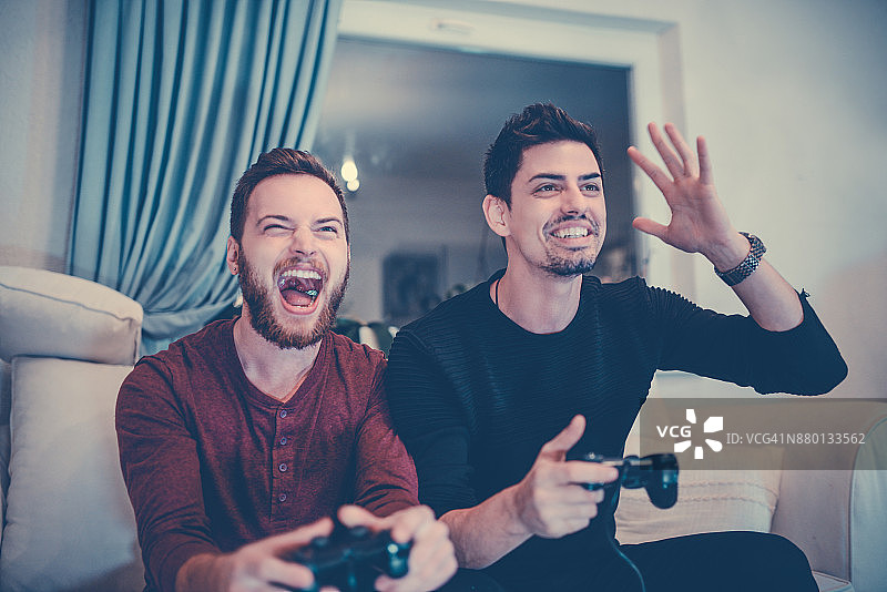 两个兴奋的朋友在玩电子游戏图片素材