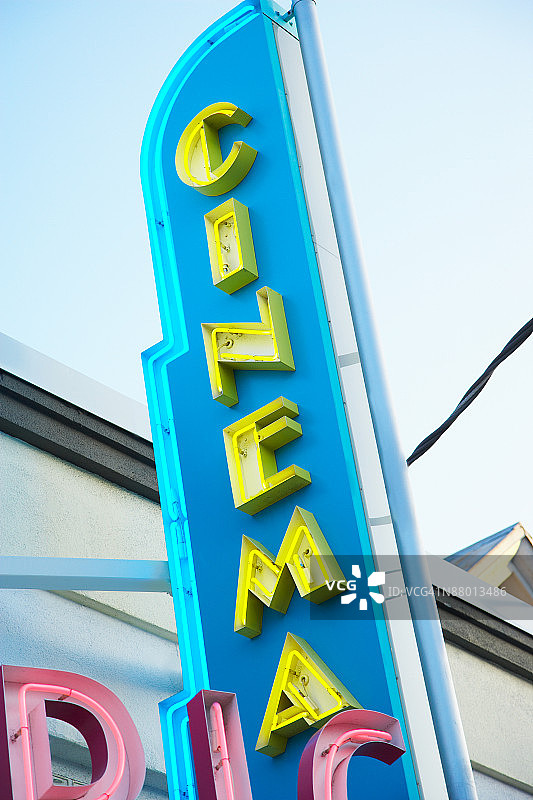 白天建筑上的霓虹电影院标志图片素材