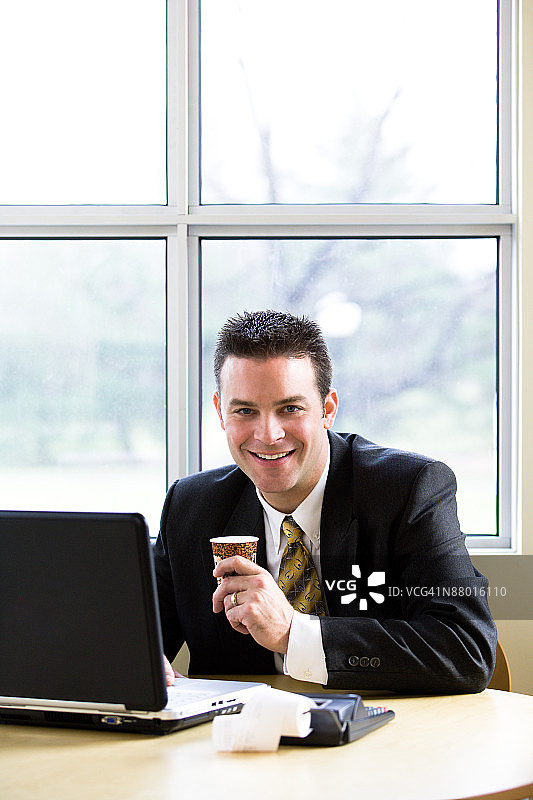 面带微笑的会计师喝着咖啡图片素材