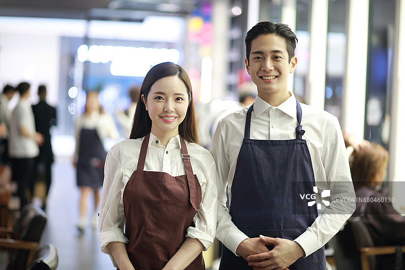 在美发沙龙摆姿势的微笑美发师图片素材