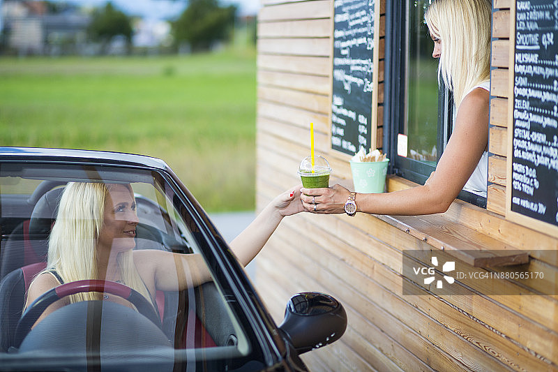 汽车餐厅里拿着冰沙的女店员图片素材