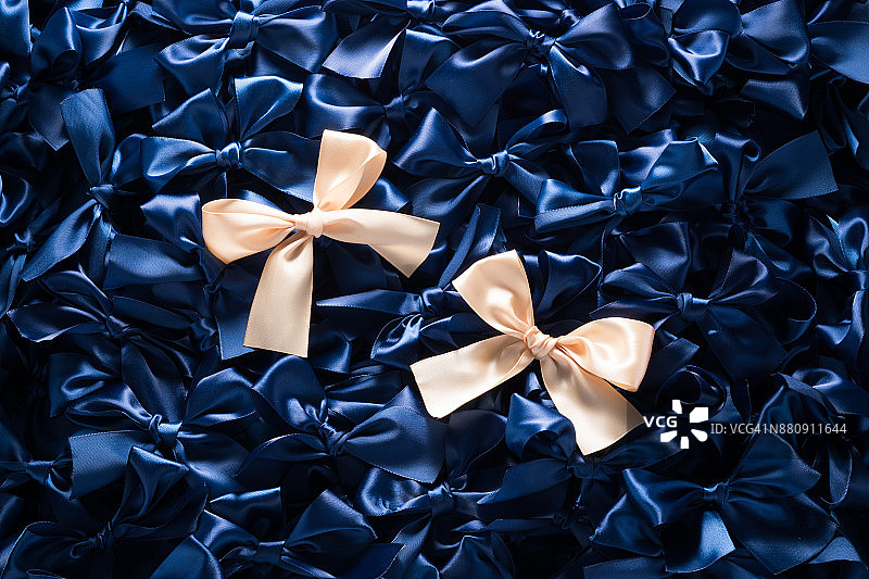 深蓝色背景上的香槟金色丝带蝴蝶结图片素材