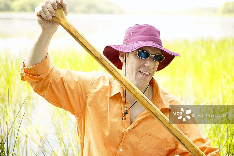 男子在湿地中划船图片素材