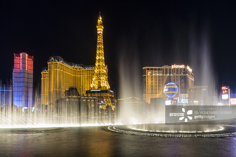 百乐宫豪华酒店度假村和巴黎拉斯维加斯酒店埃菲尔铁塔复制品前的喷泉夜景图片素材