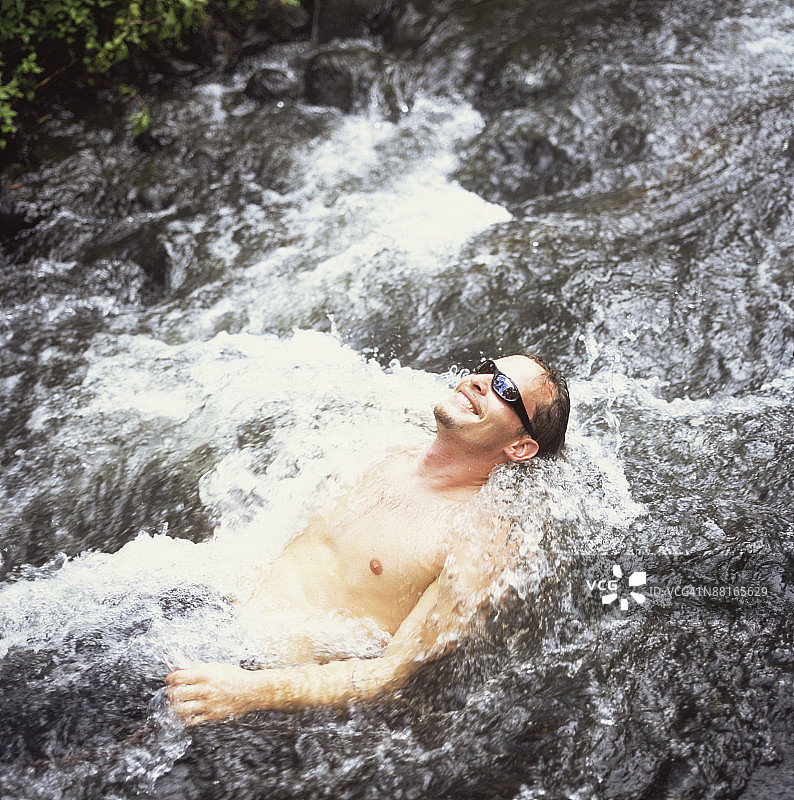 躺在水中的微笑男人图片素材