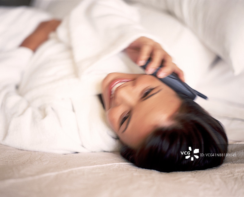 在床上使用手机的女人图片素材