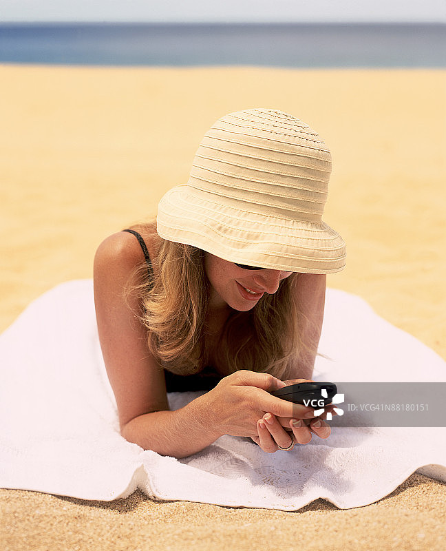 在海滩上拨打手机的女人图片素材