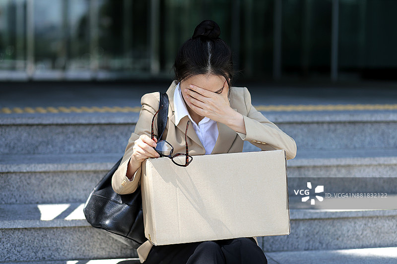 坐在办公楼台阶上的被解雇的女商人图片素材