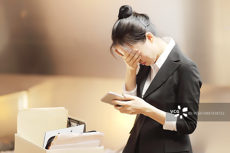 失望的女商人站在办公室的纸箱旁图片素材
