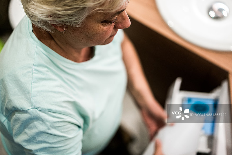 奶奶往洗衣机里倒洗衣液图片素材