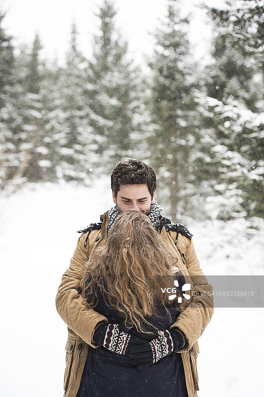 冬季风景中拥抱的幸福年轻情侣图片素材