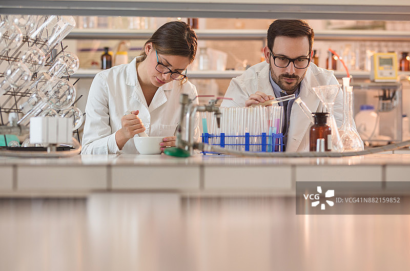 两名生化学家在实验室进行科学研究，试验化学物质图片素材