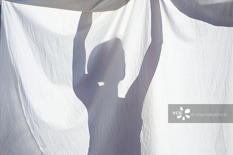 女人晾晒衣服的影子图片素材