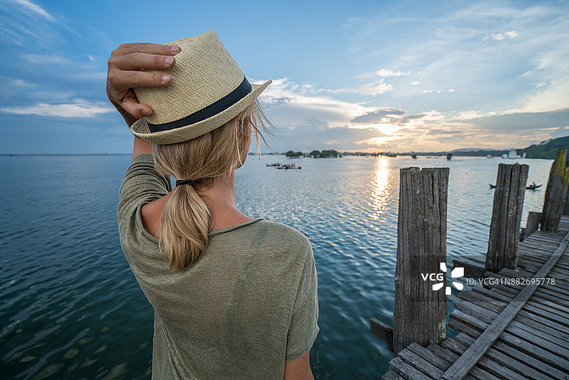在缅甸乌本桥欣赏日落的年轻女子图片素材