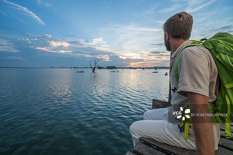 青年在缅甸乌本桥观赏日落图片素材