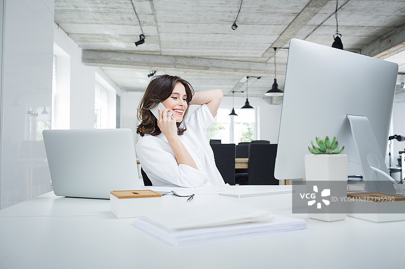 女商人在办公室用手机交谈图片素材