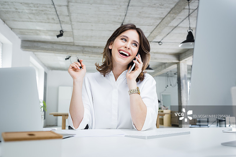 在办公室打电话的微笑女商人图片素材