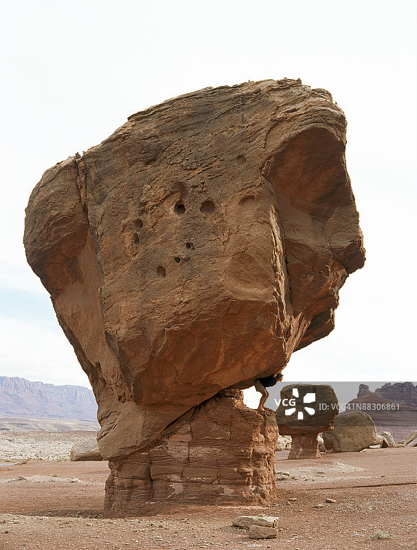 男人假装在沙漠中举起巨石图片素材