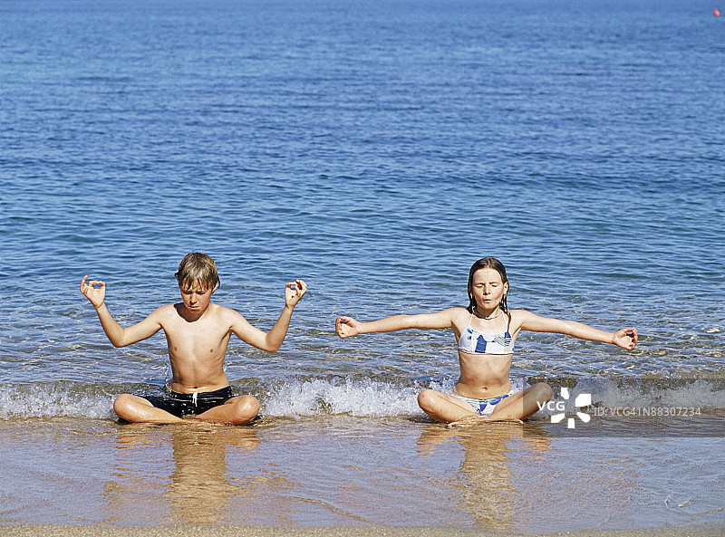 儿童在意大利撒丁岛沙滩冥想图片素材