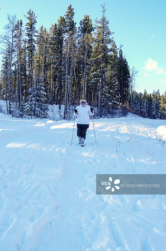 冬季假期：活跃的年长女性在雪地里北欧式健走图片素材