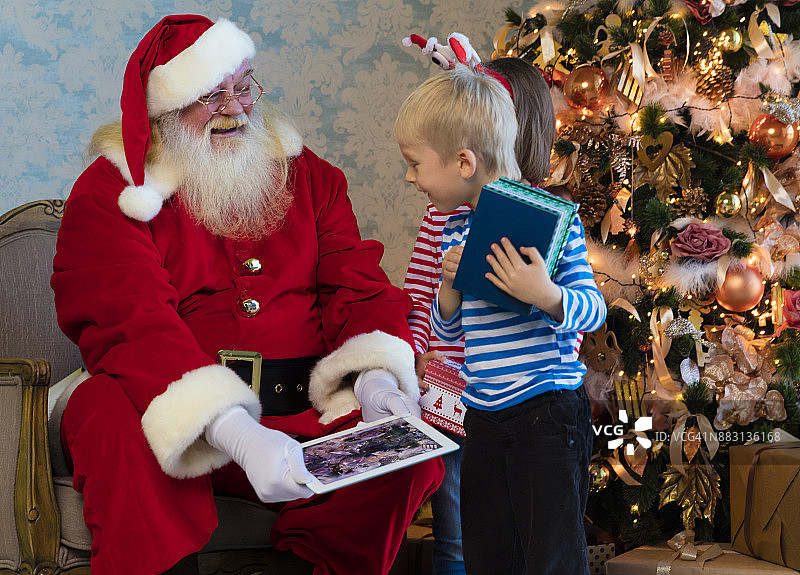 孩子和圣诞老人使用平板电脑图片素材