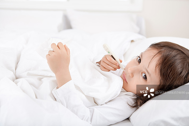 生病的女孩躺在白色卧室里图片素材