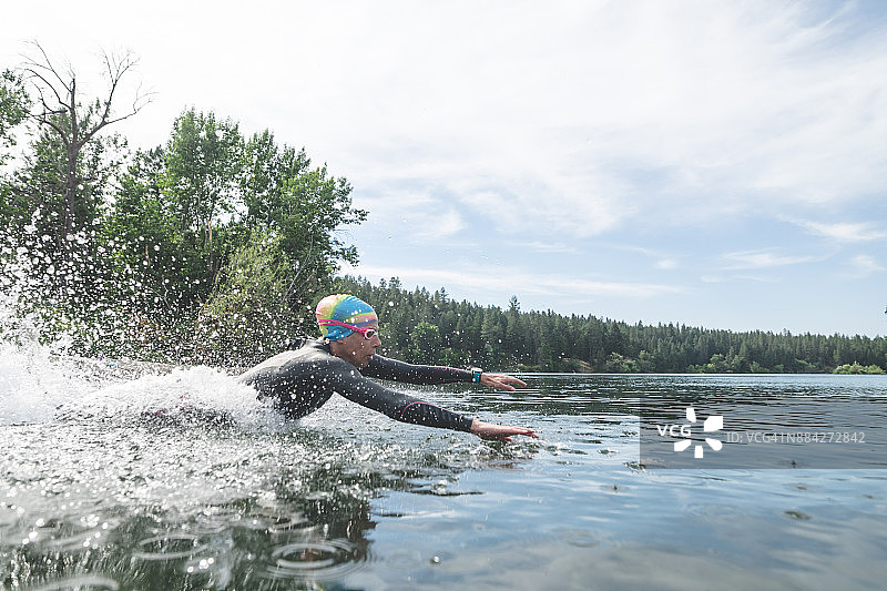 跳入水中的女子铁人三项运动员图片素材