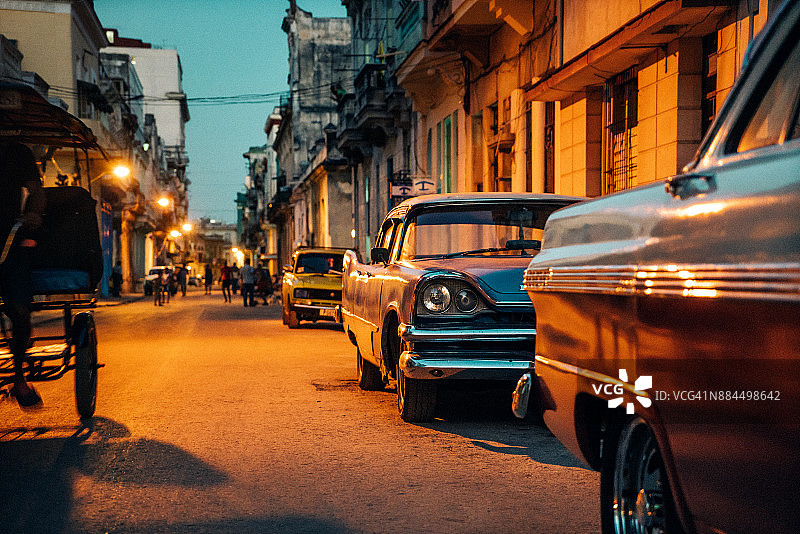 黄昏时分停在古巴哈瓦那街边的老式美国汽车图片素材