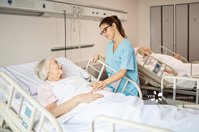 护士安慰躺在病床上的年长女性图片素材
