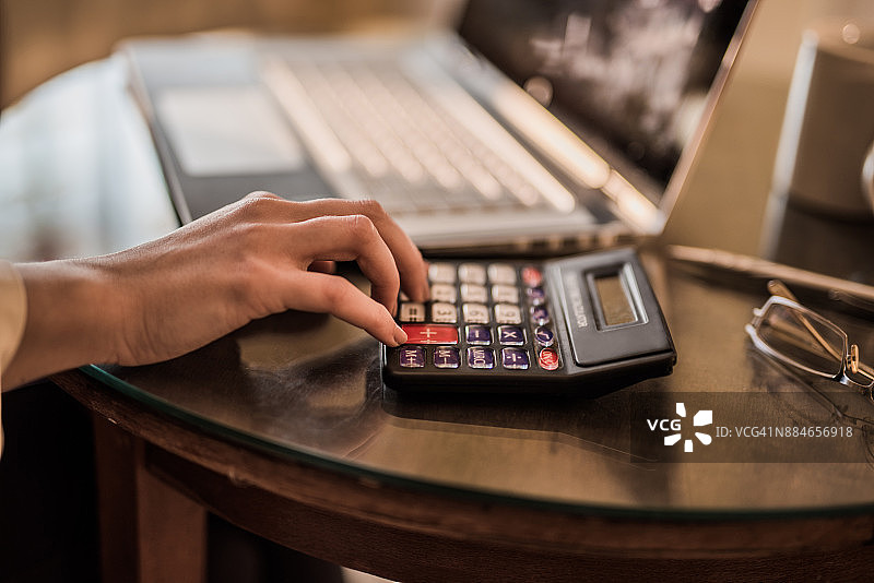 年轻女人使用计算器的特写图片素材