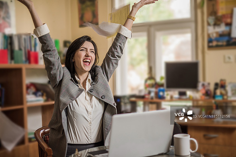 在她工作场所的快乐的年轻女子图片素材