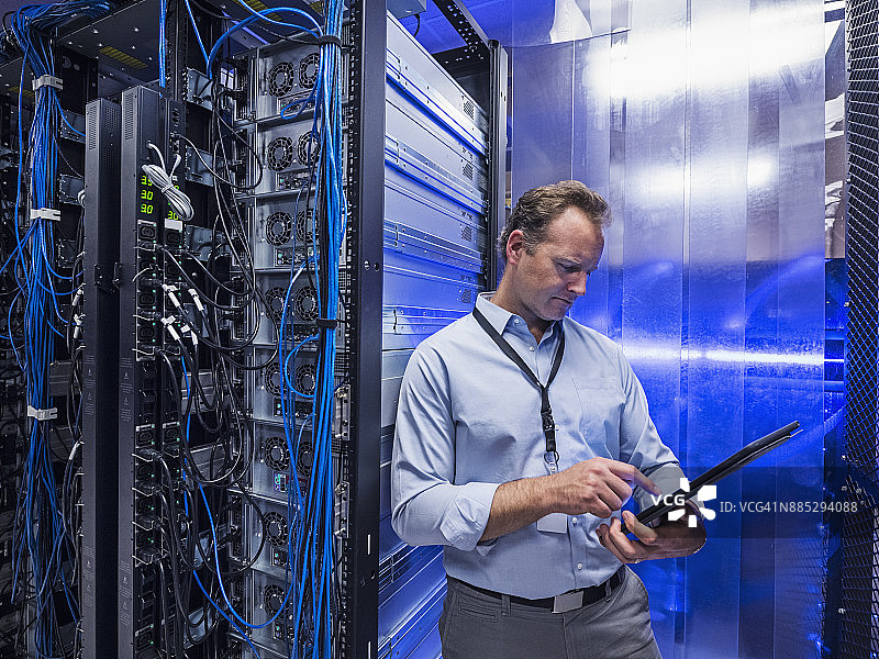 男子在服务器机房使用平板电脑图片素材