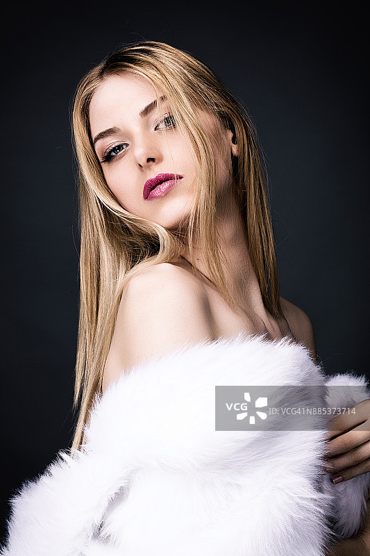 身穿白色皮草大衣的性感年轻女人图片素材