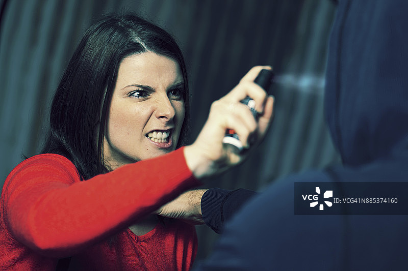 法国：手持催泪气雾剂的年轻女子图片素材