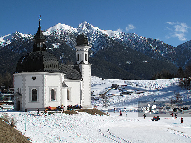 奥地利北蒂罗尔州泽费尔德Seekirchl教堂，背景是卡尔文德尔山脉的雪山图片素材