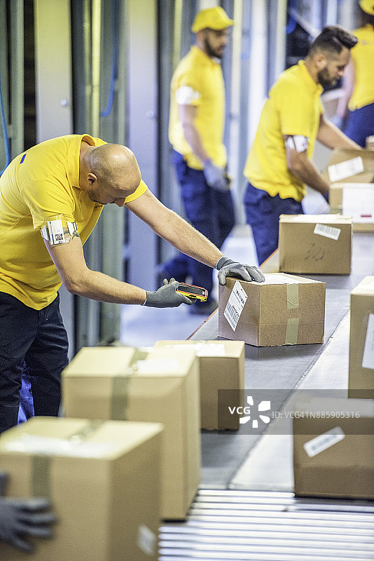 邮政工人扫描纸箱包裹图片素材