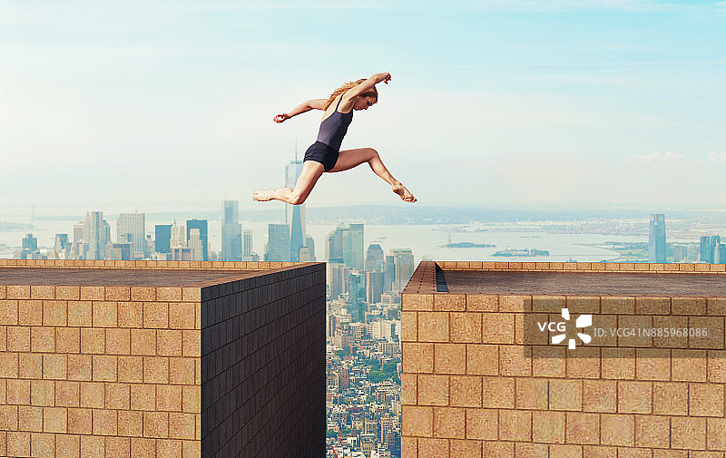 女人在两栋高楼之间危险跳跃图片素材