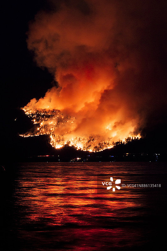 加拿大不列颠哥伦比亚省奥卡诺根湖中反射的森林火灾图片素材