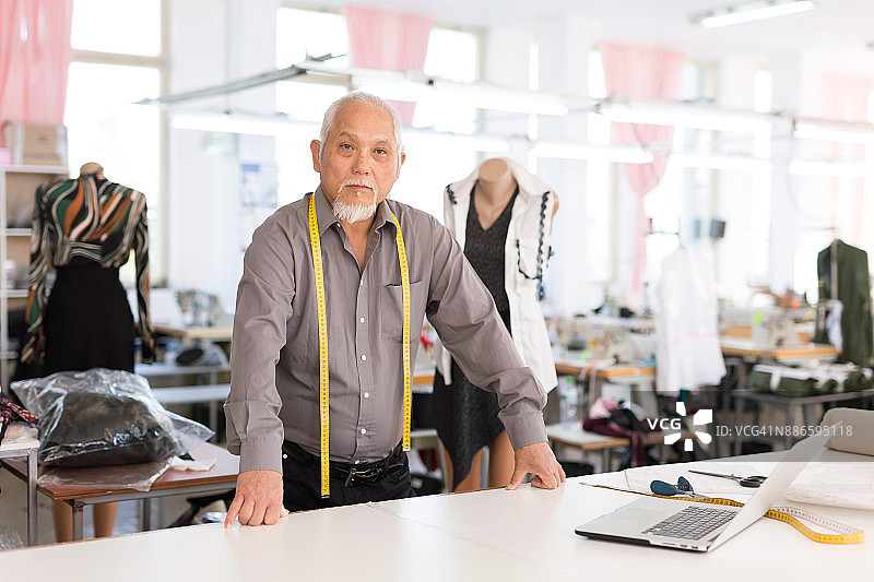 设计师在时装工作室使用笔记本电脑图片素材