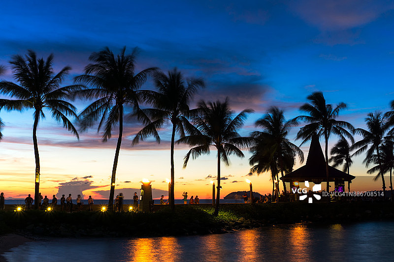 亚庇丹绒亚路海滩日落时分的棕榈树剪影图片素材