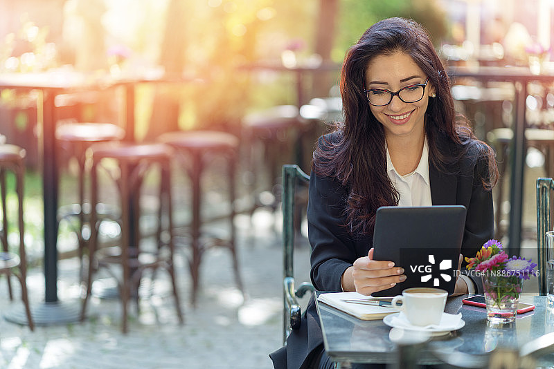 浏览平板电脑的棕发女子图片素材