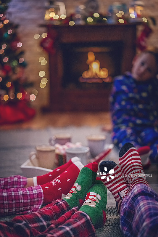 穿着睡衣和圣诞袜的可爱小朋友在圣诞节喝热巧克力图片素材