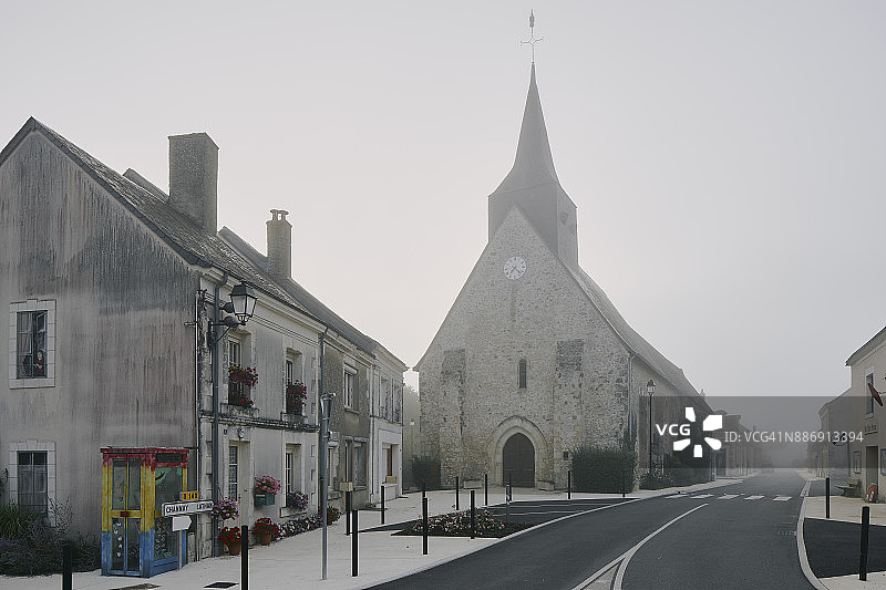 卢瓦尔河谷梅涅勒维孔特村雾蒙蒙的早晨，道路与教堂图片素材