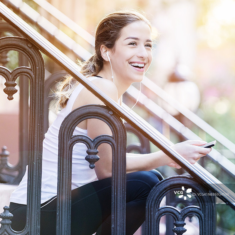 快乐的年轻女人在城市锻炼后放松身心图片素材